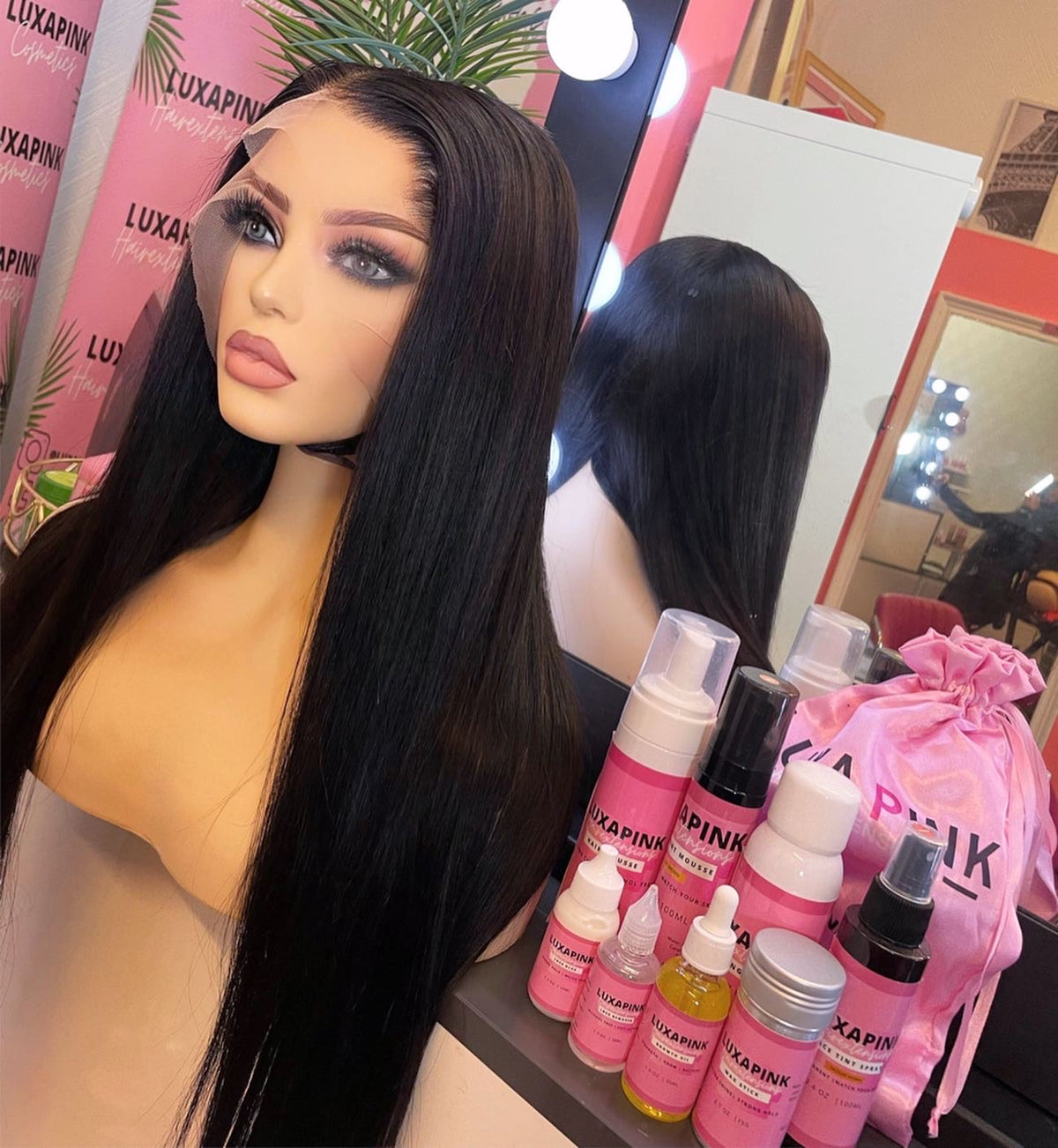 a mannequin with long black hair and a pink bag with bottles