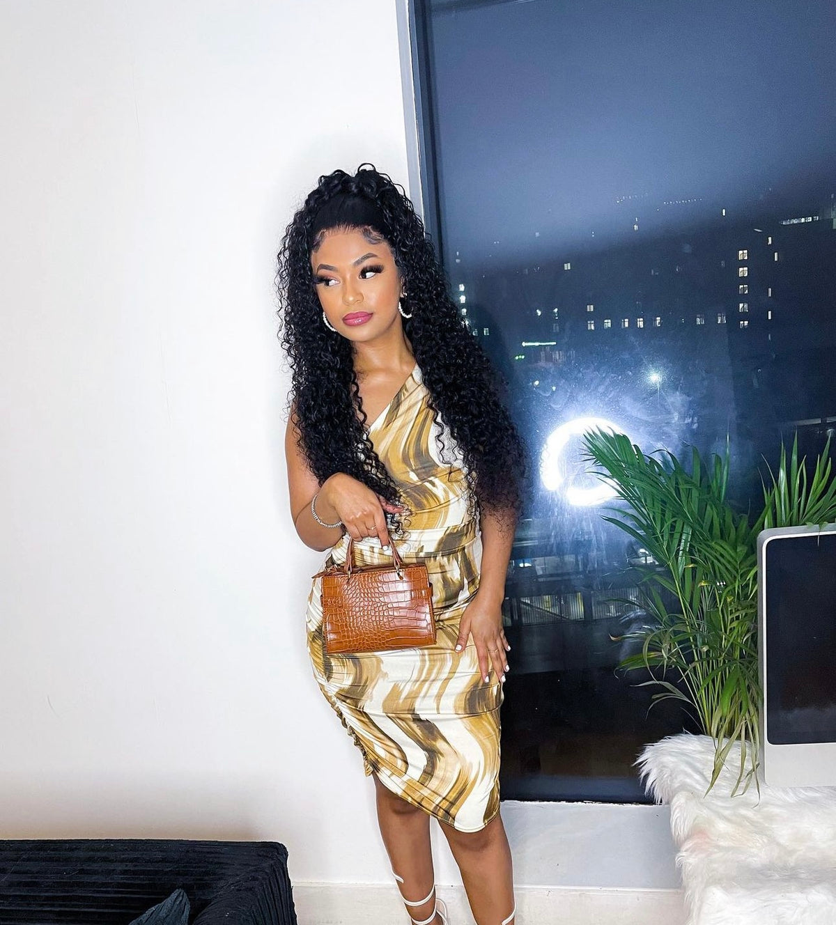 a woman with long black hair wearing a dress and holding a purse
