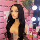 a mannequin with a wig and a pink wall with pink and white signs