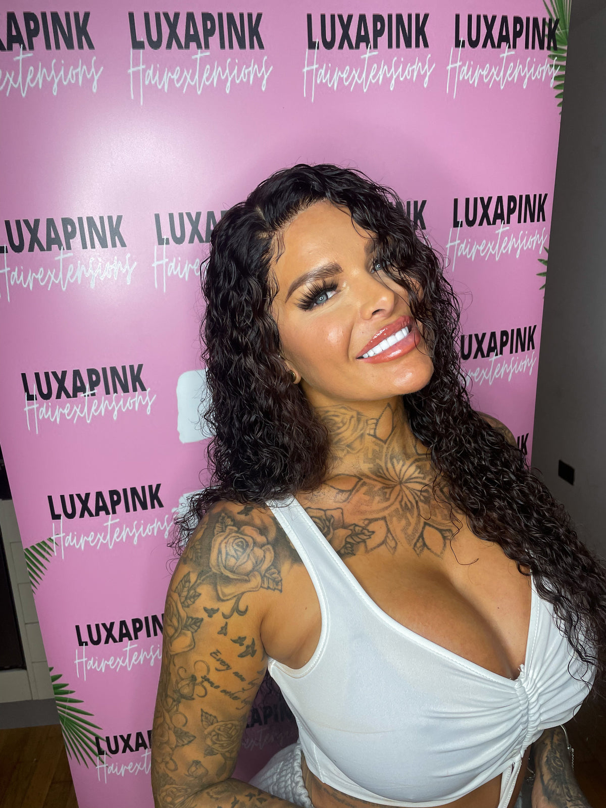 a woman with tattoos and a white tank top