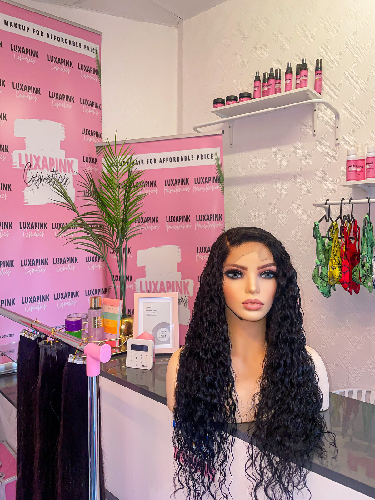 a mannequin with long black hair sitting at a counter
