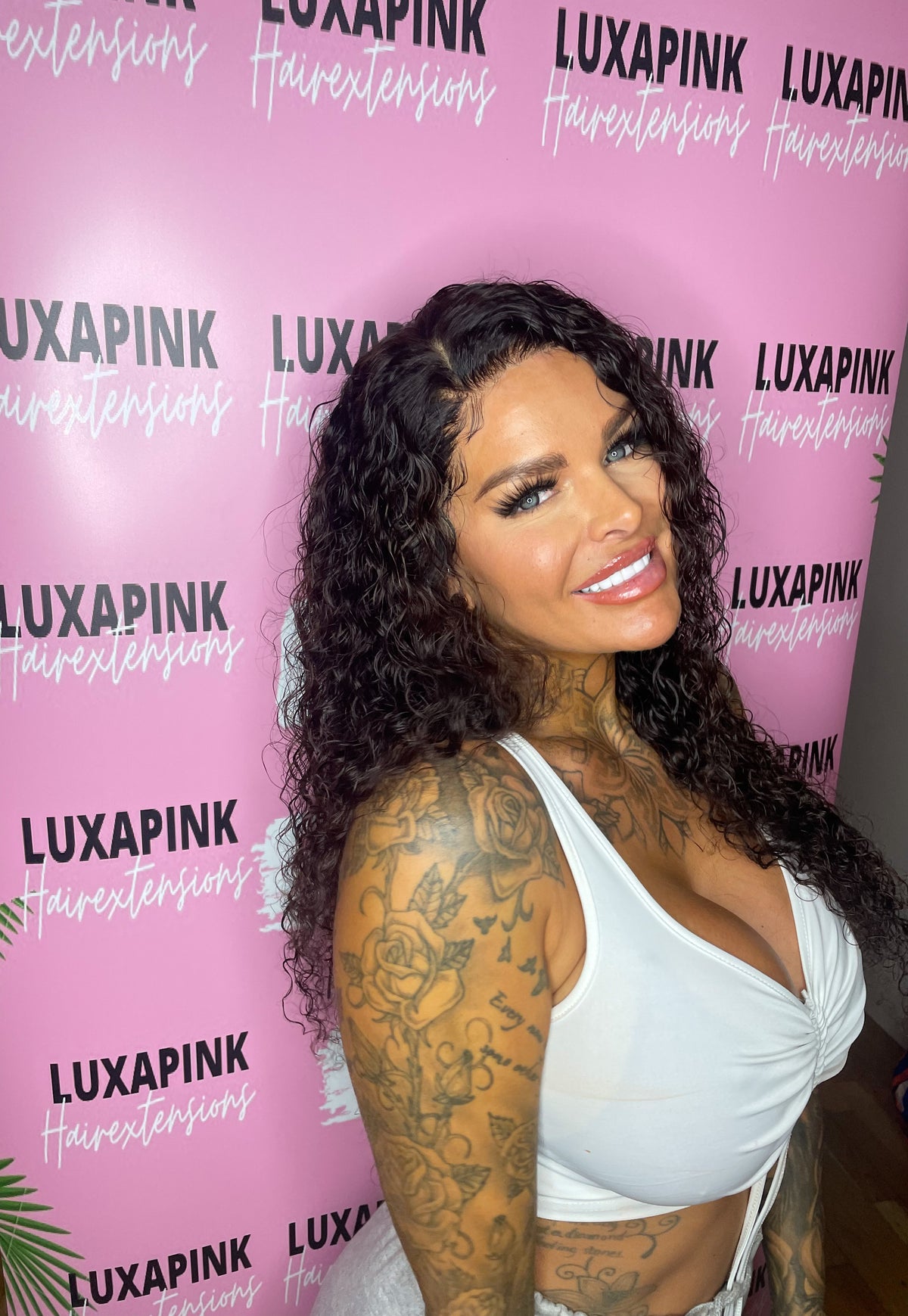 a woman with tattoos and a white tank top